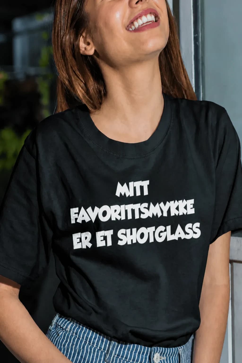 Kvinne i svart t-skjorte med teksten «Mitt favorittsmykke er et shotglass» – morsom t-skjorte for festglade