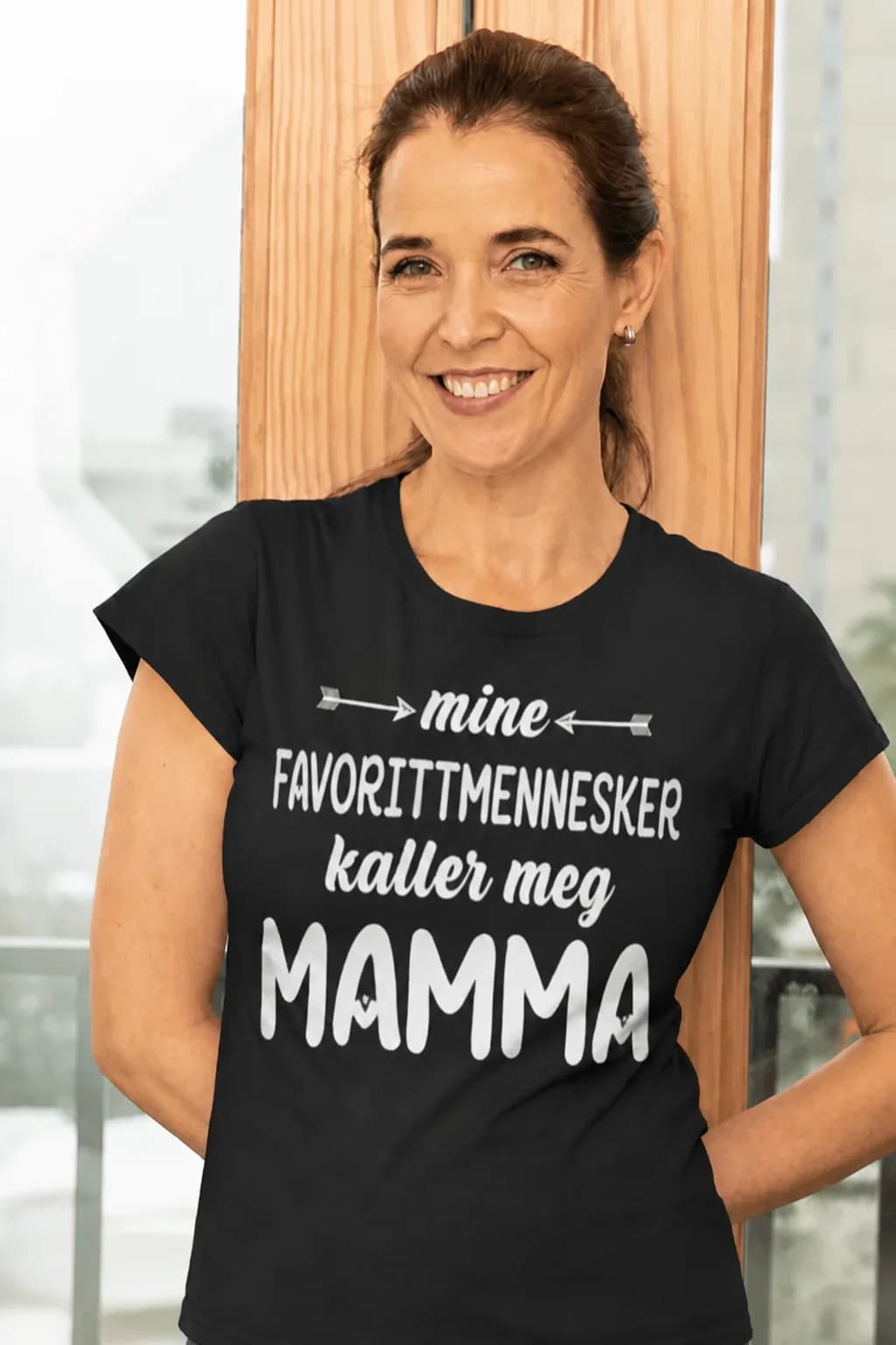 Smilende kvinne i svart t-skjorte til mamma med teksten om favorittmenneskene som kaller henne mamma