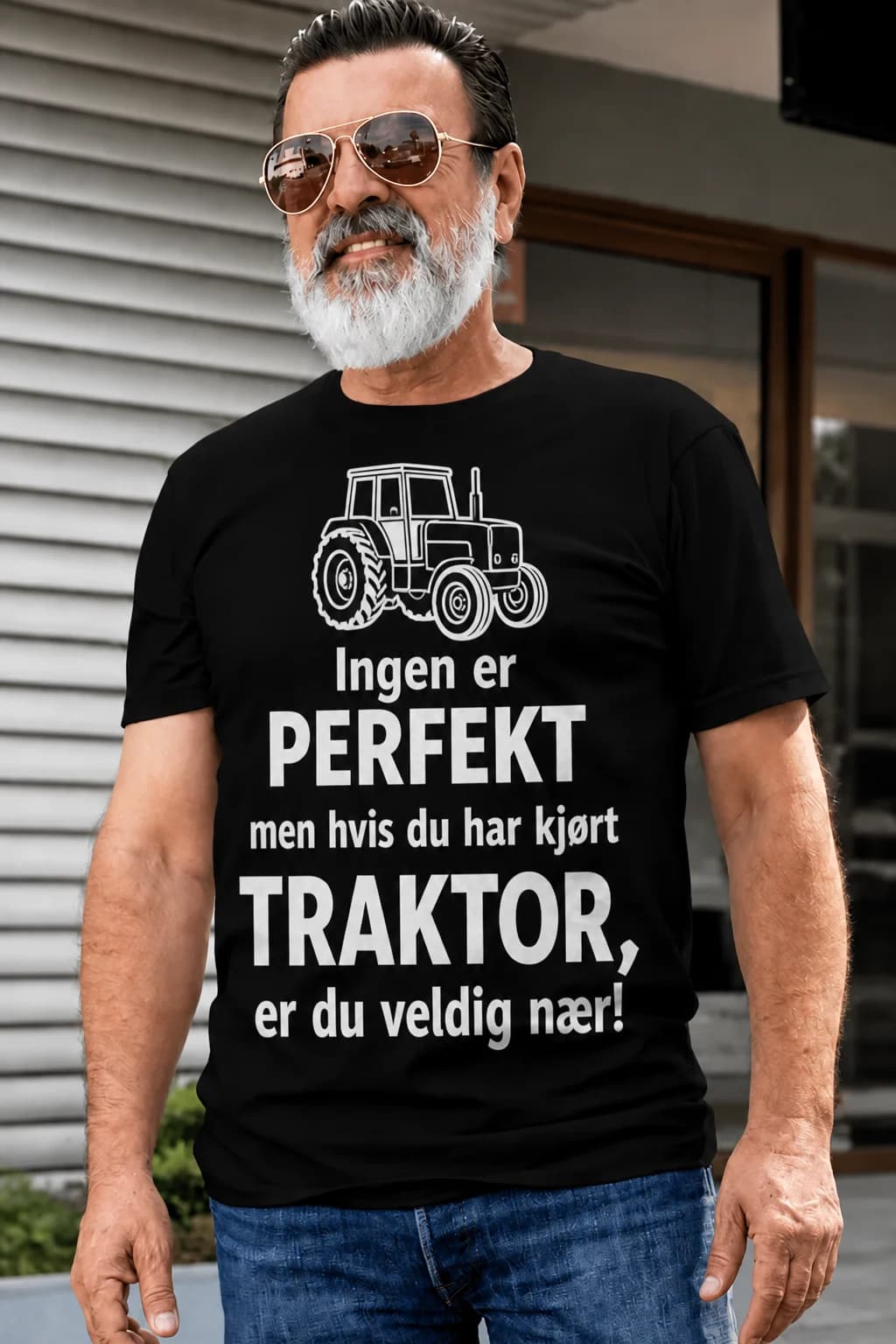 Mann med skjegg i svart t-skjorte med terrengbil og tekst om at den som har kjørt bilen er nesten feilfri