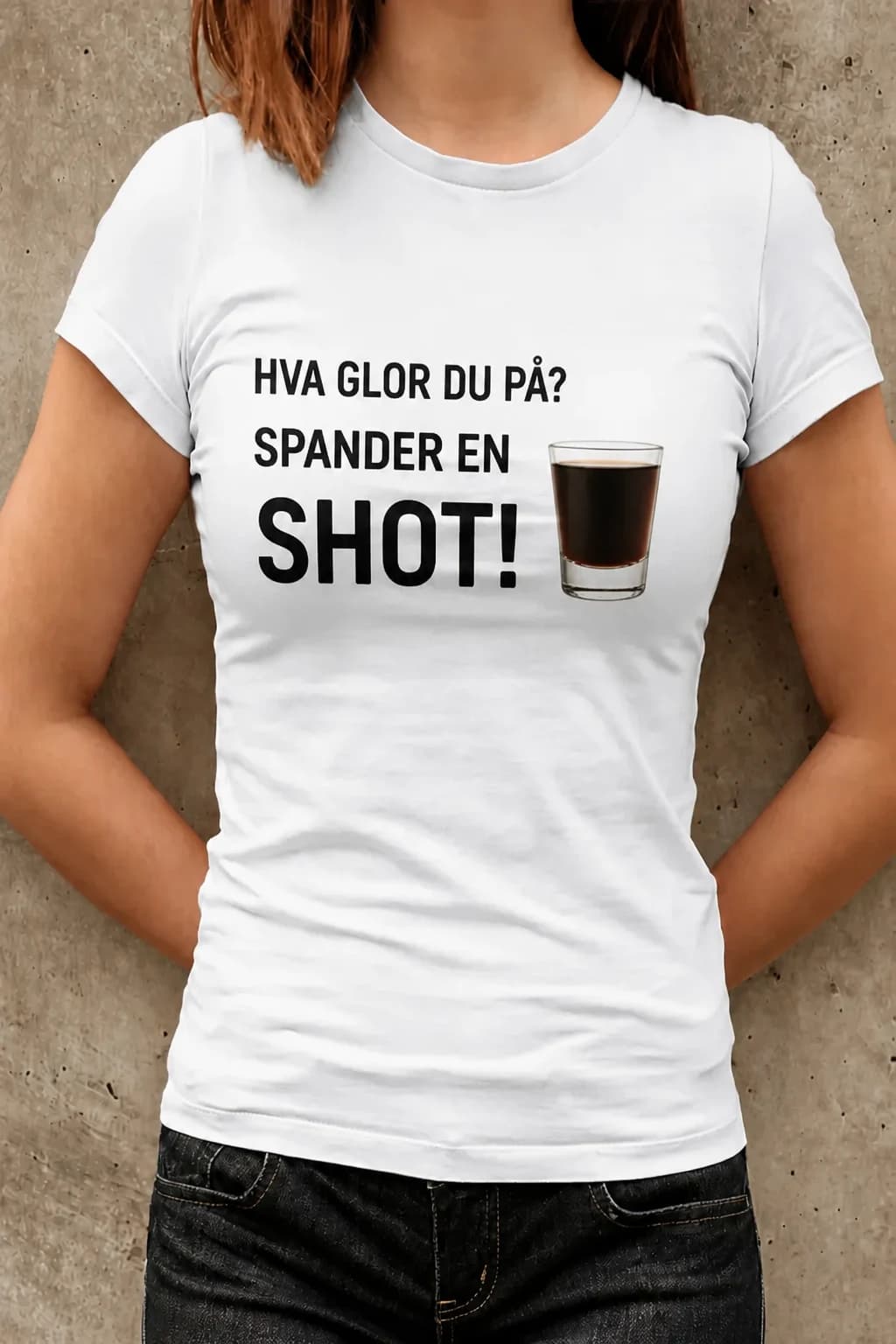 Kvinne i hvit morsom t-skjorte med svart tekst «Hva glor du på? Spander en shot!» og shotglass
