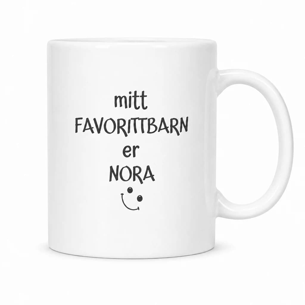 Hvitt krus med navn og sort tekst «mitt FAVORITTBARN er NORA» med et lite smilefjes