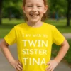 Barne t-skjorte Twin sister med navn med trykket I am with my TWIN SISTER TINA