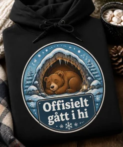 Hettegenser med søt vinterillustrasjon av en sovende bjørn i en varm hule og teksten Offisielt gått i hi