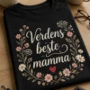 T-skjorte med teksten «Verdens beste mamma» omgitt av delikate markblomster og et lite rødt hjerte på mørk bakgrunn