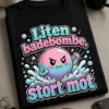 T-skjorte med teksten "Liten badebombe, stort mot" og en modig badebombe i tegneseriestil med bobler og små actionlinjer.